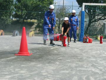 消火器の扱い方を指導する団員