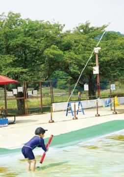 広報はむら7月15日号No.1073表紙　親水公園じゃぶじゃぶ池で遊ぶ男の子