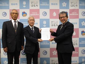 同審議会会長と副会長が、市長に答申書を渡している写真